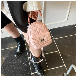 Detail showing pink quilted leather backpack with silver twist-lock and chain strap