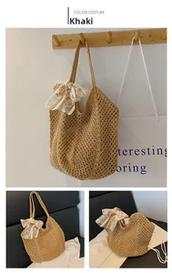 Detail of khaki woven straw tote bag featuring a large pink floral lace bow accent
