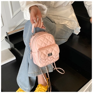 Detail of pink quilted patent leather mini backpack with silver metal turn-lock closure