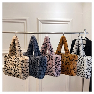 Dettaglio di cinque borse tote in peluche leopardate con texture trapuntate su gruccia