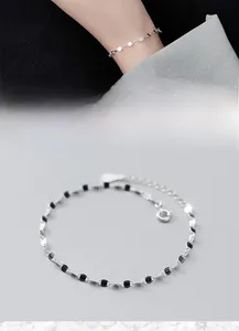 Detailed macro view of S925 silver minimalist chain bracelet with black enamel dots