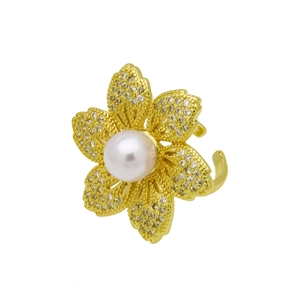 Macro detail of golden flower ring with central pearl inlay and sparkling zircon petals