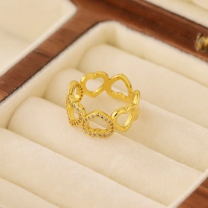 Elegant gold hollow heart ring with sparkling cubic zirconia on a beige velvet jewelry box