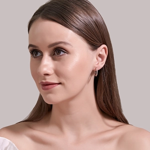 Side view of model wearing rose gold hoop earrings with sparkling zircon crystals