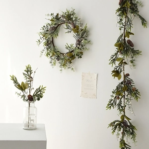Christmas wreath and garland with pine cones and white berries for festive wall decoration