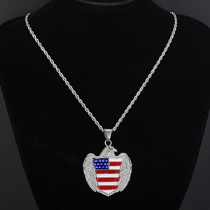 Détail macro du pendentif aigle argenté avec émail drapeau américain et chaîne torsadée