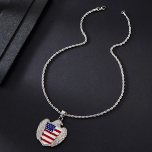 Détail macro du pendentif cœur aigle plaqué or avec émail drapeau USA et chaîne
