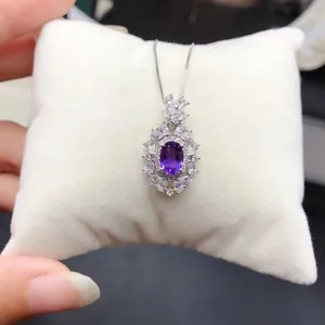 Détail d'un collier pendentif améthyste violette avec des grappes de zircons blancs