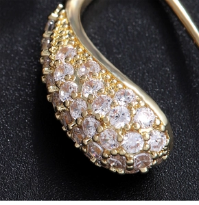 Macro shot of curved gold-plated hook earring with micro-pave cubic zirconia setting