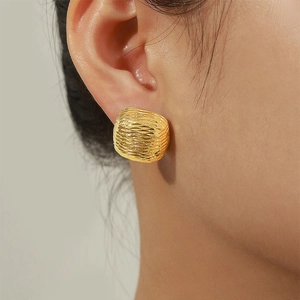 Minimalist square textured gold hoop earrings featuring a unique woven pattern on a model