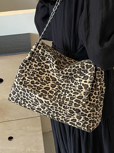 Large leopard print chain tote bag with landscape pattern on model in black dress