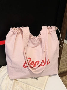Pink canvas tote bag with red Beach letter print and drawstring closure for daily travel
