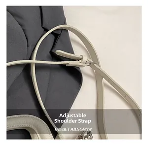 Detail view of adjustable cream faux leather shoulder strap with silver metal buckle