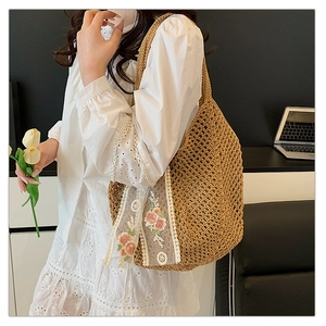 Detail of hand-woven tote bag featuring white lace patterns and floral embroidery