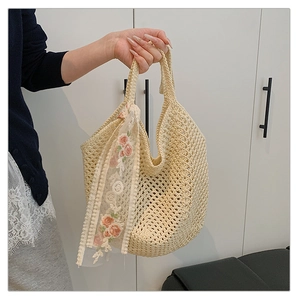 Detailed close-up of woven tote bag featuring delicate pink floral lace ribbon and handles