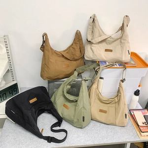 Detail showing five colors of large minimalist hobo tote bags with leather logo patch