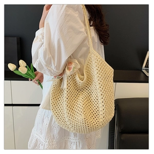 Detail of beige crochet tote bag with pink floral scarf and hollow woven texture