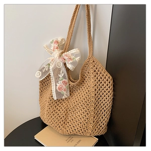 Detail of woven texture on crochet tote bag with pink floral lace bow accessory