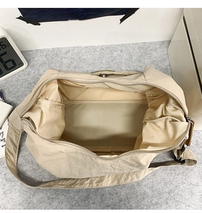 Interior view of large beige nylon tote bag showing spacious main compartment and inner pocket