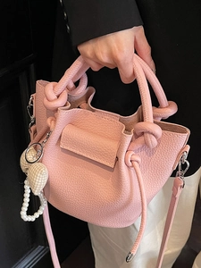 Pink lychee texture bucket bag with knotted handle and heart pearl charm detail