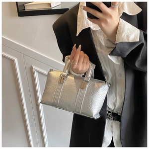 Detail of silver boston handbag with lychee pattern texture and metallic finish