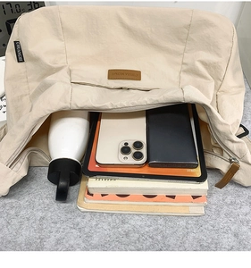 Top view showing large capacity of beige tote bag with daily essentials inside