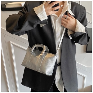 Detail of silver metallic leather handbag with wrinkled texture and sturdy handle