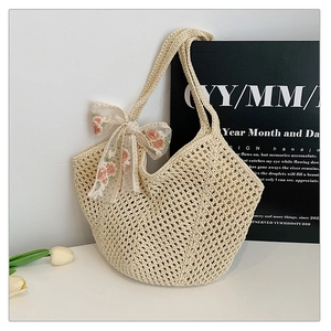 Close-up of cream crochet tote bag with lace floral embroidery bow detail