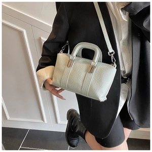 Detail showing the mint green textured leather handbag with silver metallic buckles