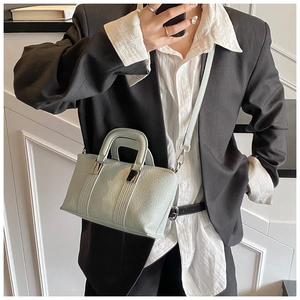 Detail showing mint green PU leather texture and silver metal hardware on a square handbag