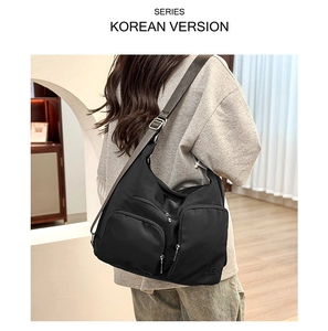 Detailansicht einer schwarzen Nylon-Hobo-Tasche mit Multi-Pocket-Design und Gurt