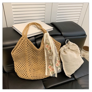 Detailed close-up of a woven straw tote bag with floral lace ribbon and linen inner pouch