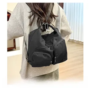 Praktische schwarze Nylon-Hobo-Tasche mit mehreren Taschen am Modell für den Alltag