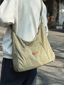 Minimalist sage green nylon tote bag with wide strap for casual commuting in urban style