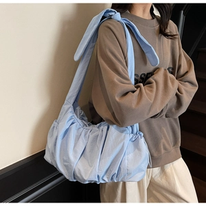 Detalle del bolso nube azul claro con textura plisada y correa ancha de hombro cómoda
