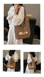 Detail der braunen Strohtasche mit grauen Karoschleifen und niedlichen Anhängern