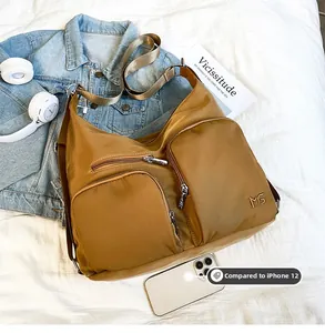 Detailansicht der Nylon-Tasche in Karamell mit Vergleich zur iPhone-Größe