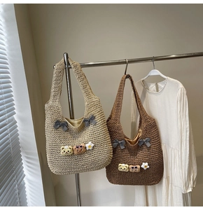 Detailansicht von gewebten Strohtaschen in Beige und Braun mit Bärenanhängern