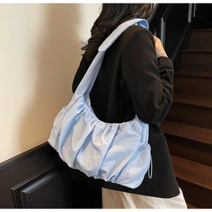 Detalle del bolso plisado azul claro con diseño de nube texturizado al hombro