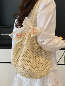 Chic hollow woven beige tote bag with floral embroidered bow on a shoulder strap