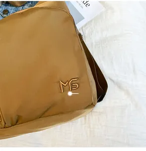 Makroaufnahme der MS-Stickerei auf brauner Nylon-Tasche mit feiner Stoffstruktur