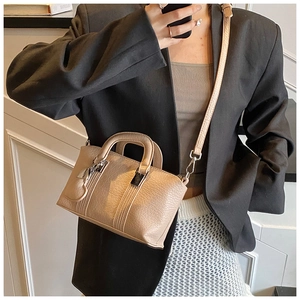 Detail showing litchi grain texture on beige mini handbag with silver hardware