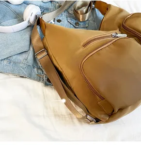 Detailansicht braune Nylontasche mit mehreren Reißverschlusstaschen und verstellbarem Gurt