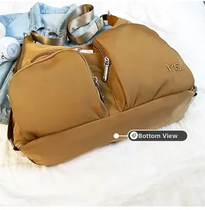 Detailansicht der khakifarbenen Nylon-Umhängetasche mit Multi-Taschen und MS-Logo aus Metall
