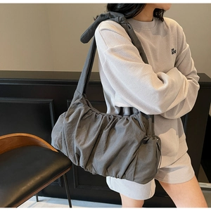 Detalle del bolso de nube plisado gris con correa de nudo elegante y tejido mate