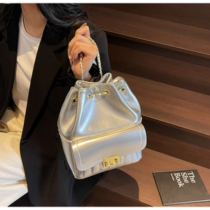 Dettaglio della borsa a secchiello argento con pelle metallizzata e tracolla a catena oro