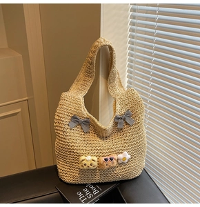Detail der Strohtasche mit Gingham-Schleifen und Plüschbär-Anhängern für Damen