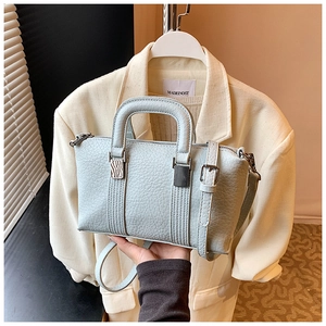 Detailed close-up of light blue pebble grain leather handbag with silver hardware details