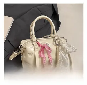 Detail of cream Boston bag with bow embroidery, plaid ribbon and pearl lace charm