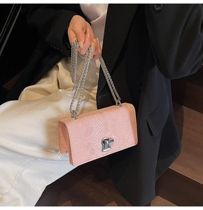 Detailed close-up of pink snakeskin pattern texture with silver chain and metal twist lock